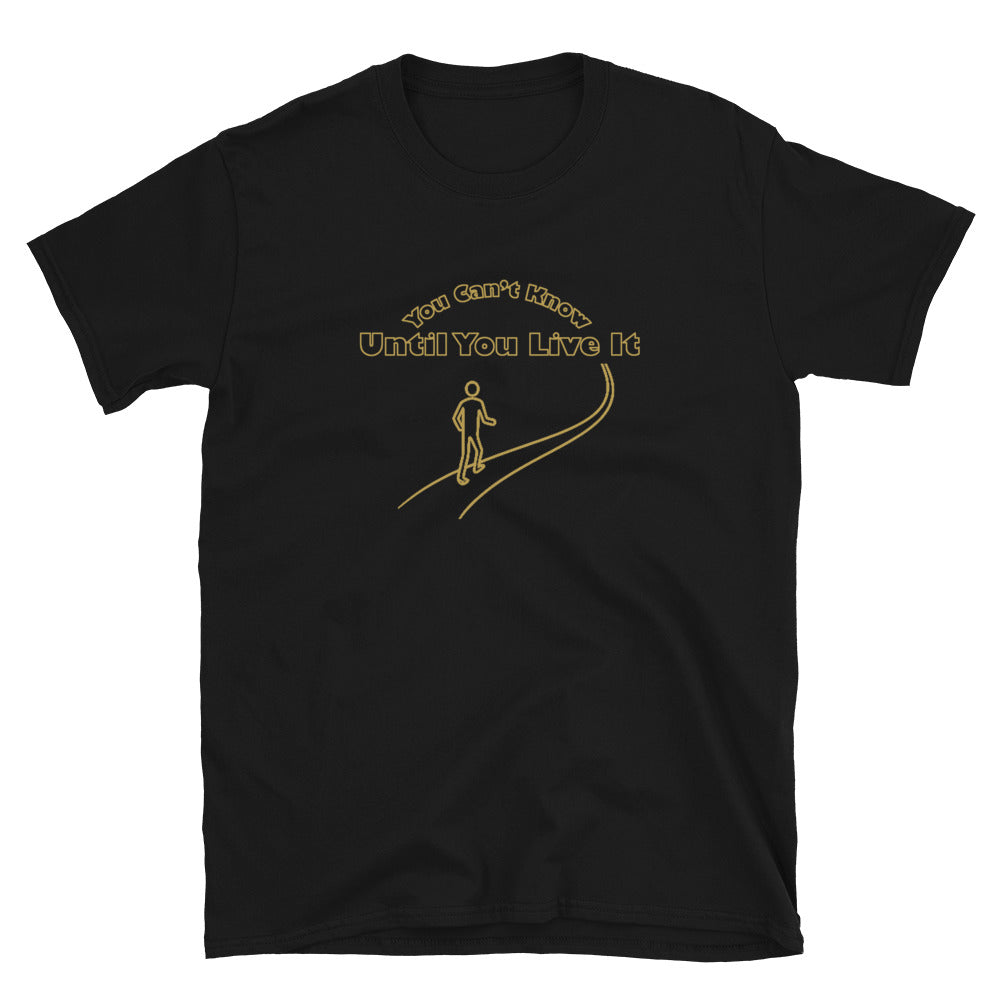 Black short sleeve t-shirt with text in gold ink "You Can't Know Until You Live It" with the outline of a person walking on a path.