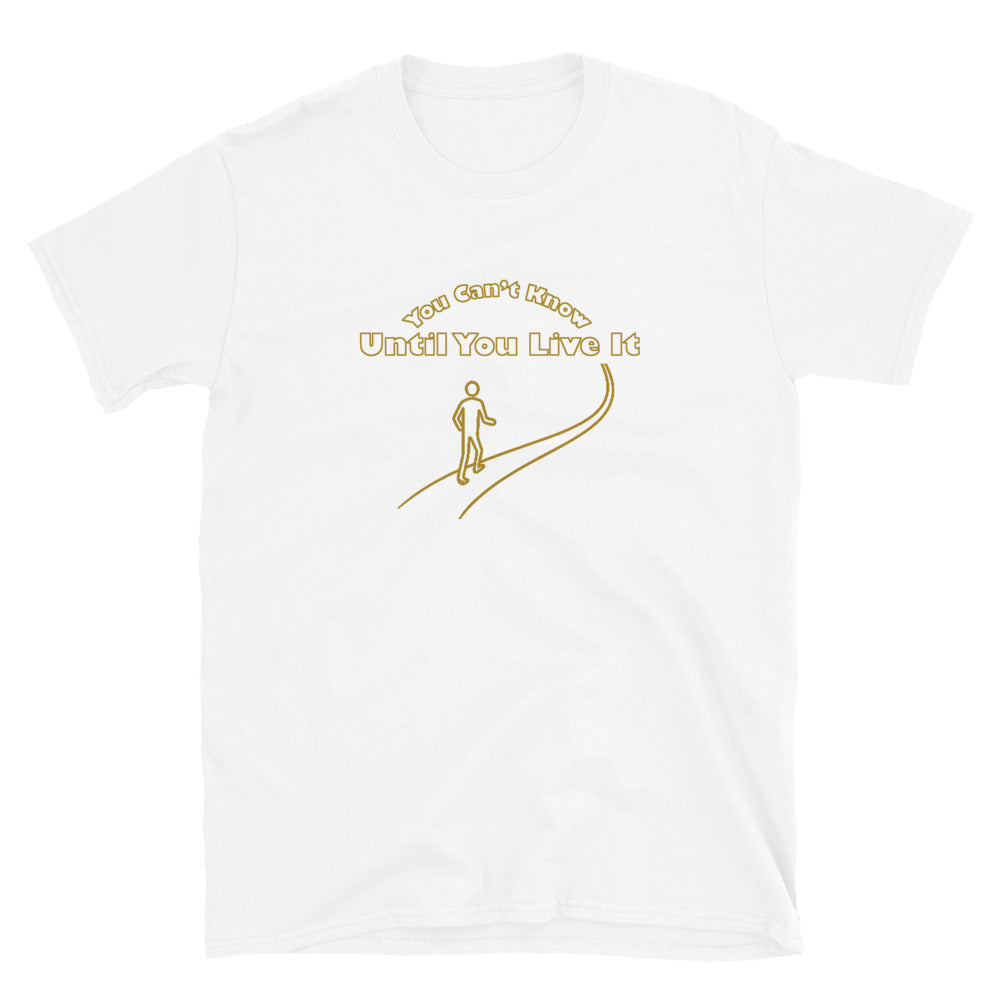 White short sleeve t-shirt with text in gold ink "You Can't Know Until You Live It" with the outline of a person walking on a path.