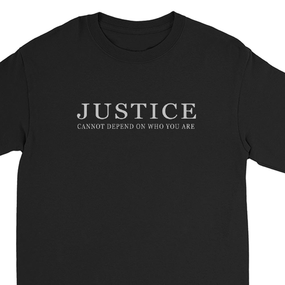 A black long sleeve crewneck t-shirt with the text 'JUSTICE CANNOT DEPEND ON WHO YOU ARE' printed in silver across the chest.