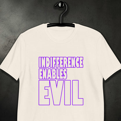 A white crewneck t-shirt hanging on a black hanger against a dark textured background. The shirt features a bold graphic text print in purple that reads 'INDIFERENCE ENABLES EVIL'.