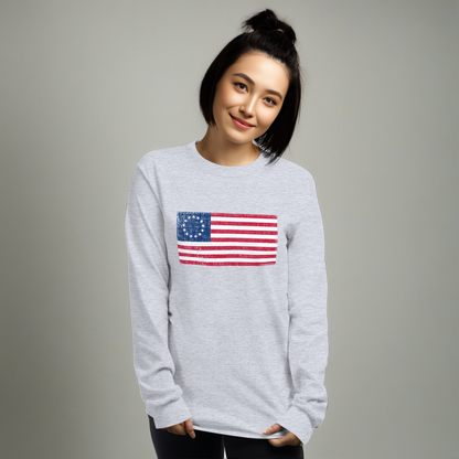 Person wearing sport grey long sleeve -shirt with a distressed image of the Betsy Ross Flag.