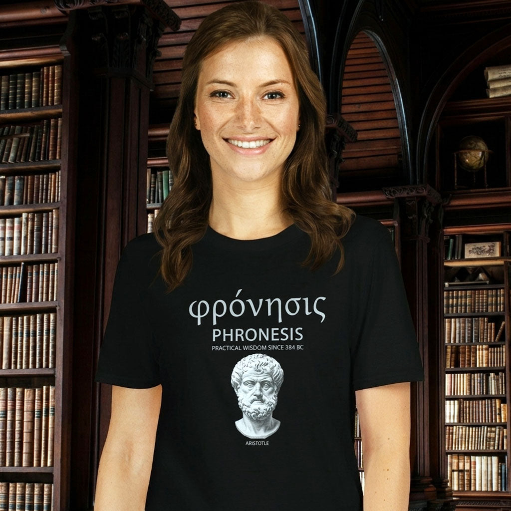 Woman wearing a black t-shirt  featuring Aristotle design with Greek word φρόνησις (Phronesis), text “Practical Wisdom Since 384 BC,” and Aristotle illustration.