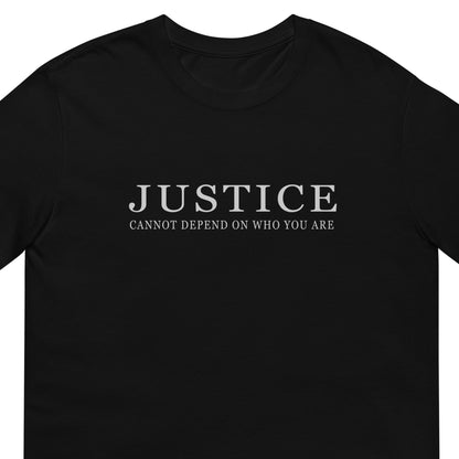 A black short-sleeve crewneck t-shirt with the text 'JUSTICE CANNOT DEPEND ON WHO YOU ARE' printed in white serif font across the chest.