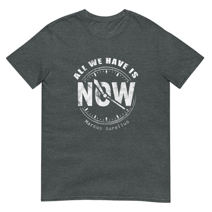 Dark heather unisex t-shirt with white line drawing of a clock showing “NOW” at the center and the quote “All We Have Is” above it in an arch and "Marcus Aurelius" in small font underneath the clock.
