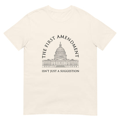 Natural t-shirt with the text "The First Amendment" in an arch over a line drawing of the US Capitol. A line of text across the bottom of the design "Isn't Just A Suggestion"
