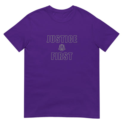 Purple t-shirt with text outlined block letters "Justice First" with a line drawing of the scales of justice between the words in silver ink.