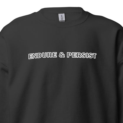 A close-up of a black crewneck sweatshirt featuring the words 'ENDURE & PERSIST' printed across the chest in capital letters.