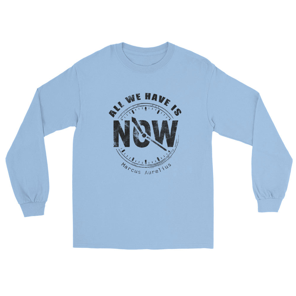 Light blue long sleeve t-shirt with black line drawing of a clock showing “NOW” at the center and the quote “All We Have Is” above it in an arch and "Marcus Aurelius" in small font underneath the clock.