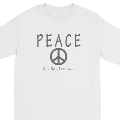 A white long-sleeve crewneck t-shirt featuring a dark gray graphic print on the front with the word 'PEACE', a peace symbol, and the text 'It's Not Too Late'.